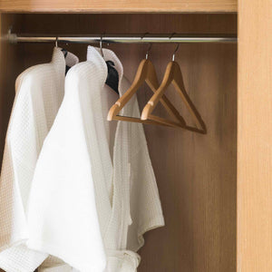 Light wood hangers with hood in hotel bedroom wardrobe